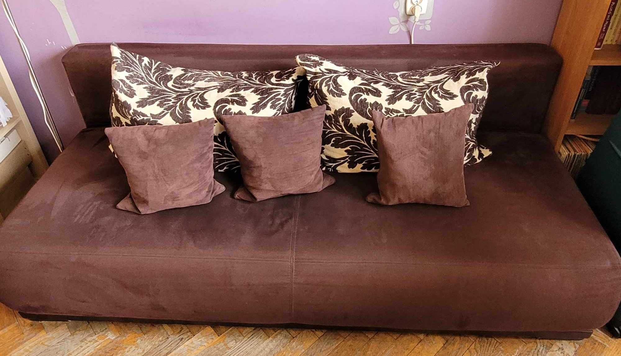 Rozkładana sofa w kolorze  czekolady z ozdobnymi poduszkami
