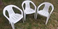 Trzy białe krzesła ogrodowe