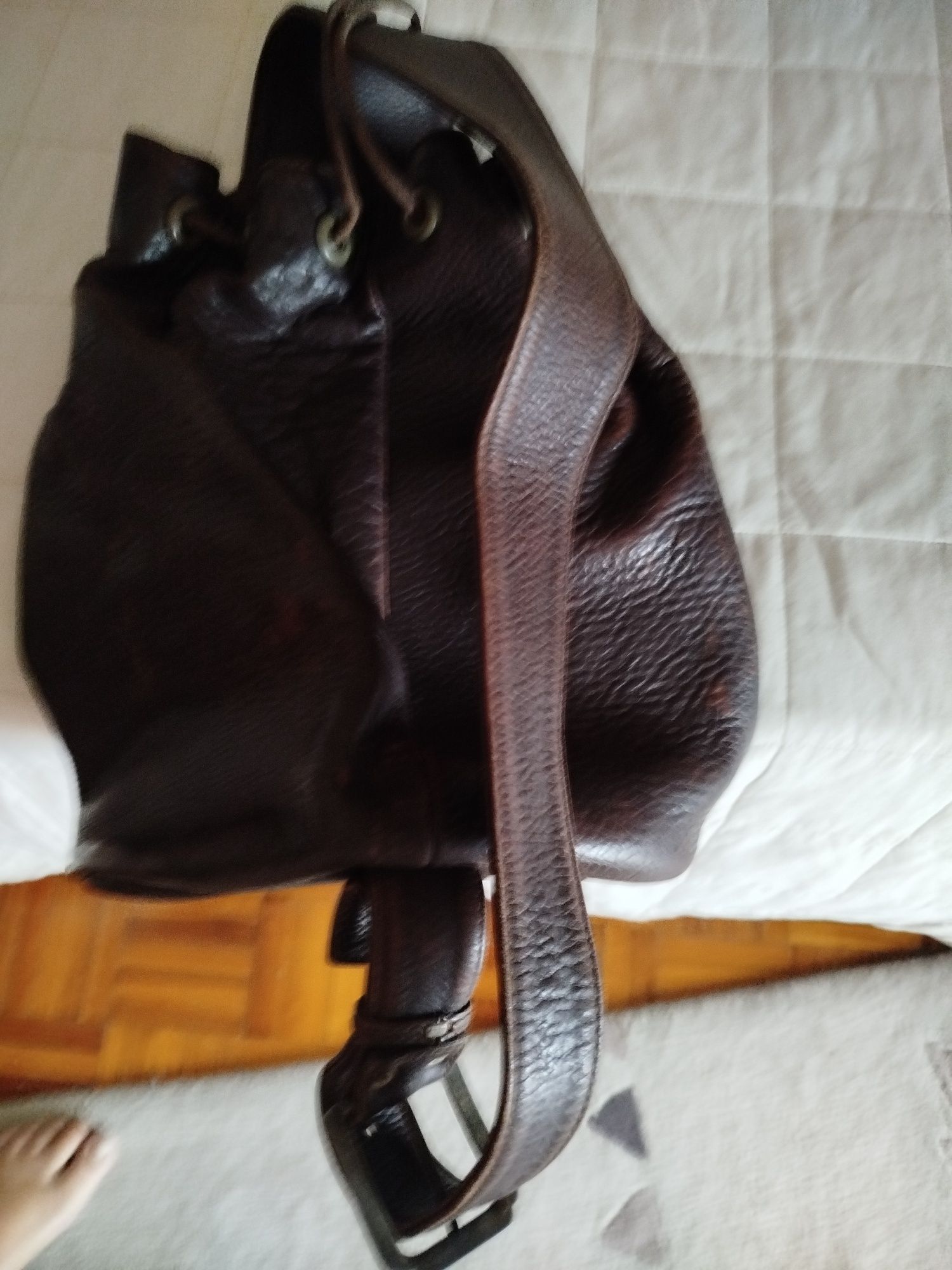 Mochila em pele castanha e bolsa preta . Ambas em pele