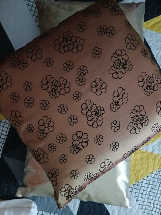 Almofadas em dourado e outra estampada