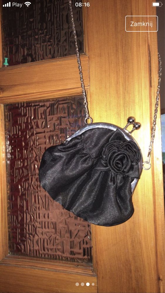 Czarna torebka z różą na srebrnym łańcuszku.