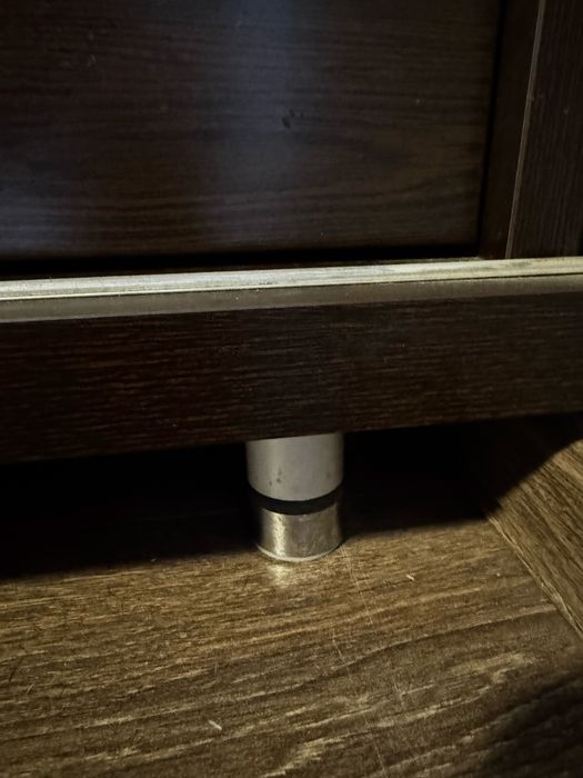 Czarna komoda z szufladami, szklany blat.