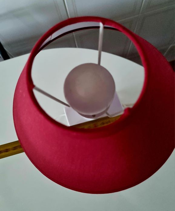 Candeeiro de mesa, feito com uma garrafa branca e abajour vermelho.