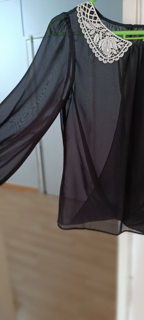 Camisa preta com gola bordada em branco. Aberta atrás. Tecido transpar