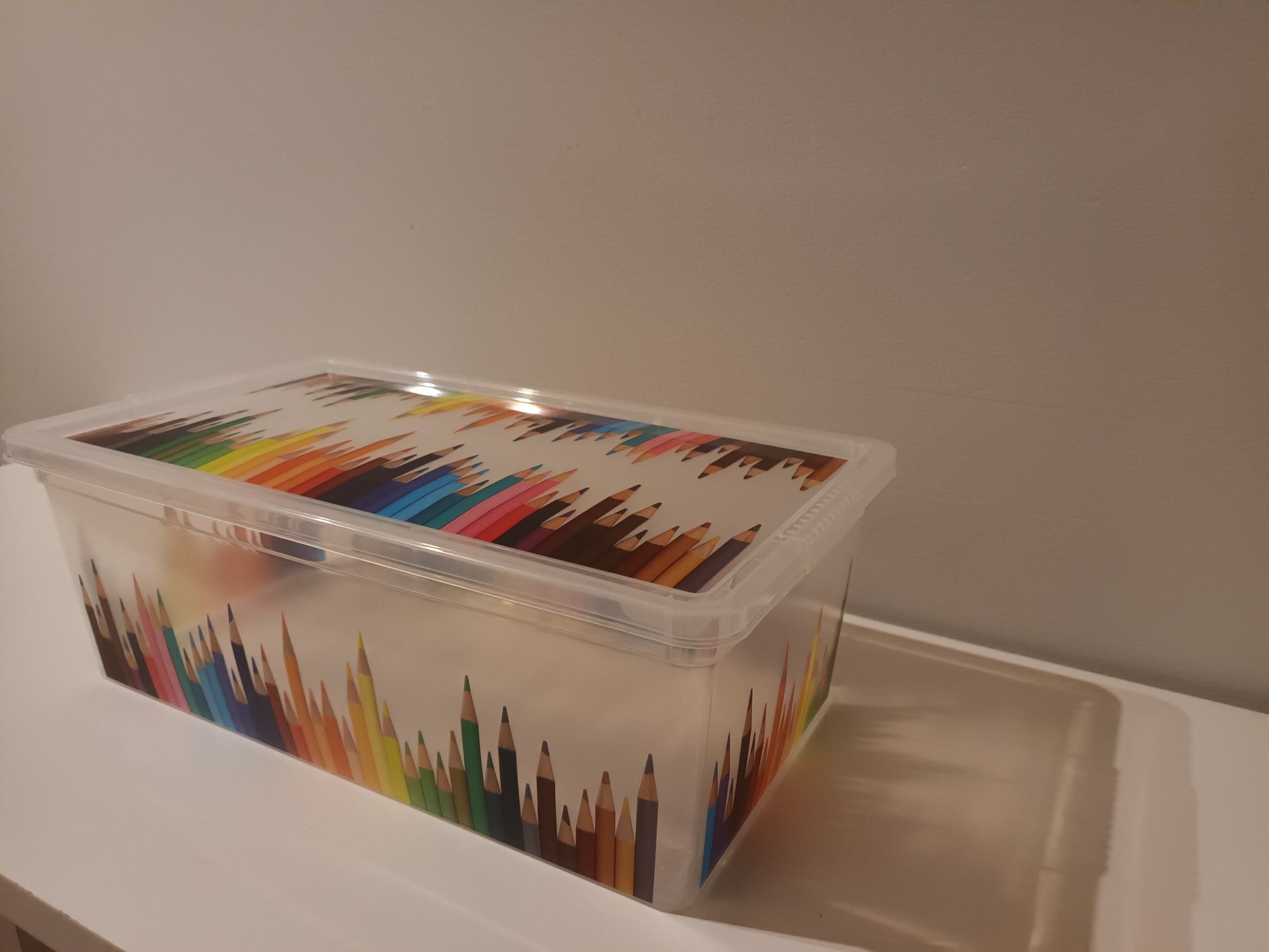 Caixas plásticas com lápis desenhados