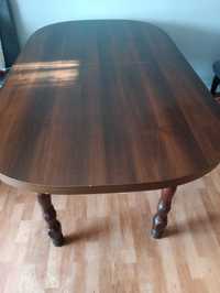 Porządny owalny stół o drewnianej konstrukcji.