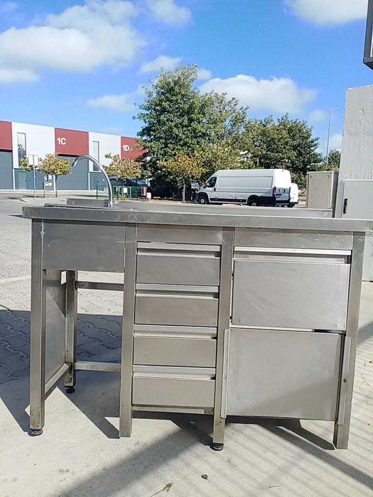 Bancada em aço fixa à parede com lavatório à esquerda e gavetas.