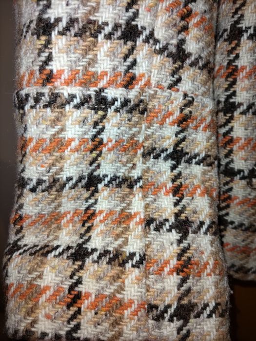 Casaco padrão xadrez castanho, laranja e bege.