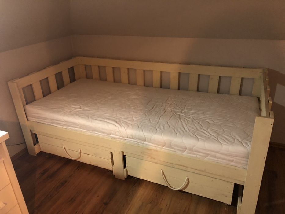 drewniane łóżko z materacem