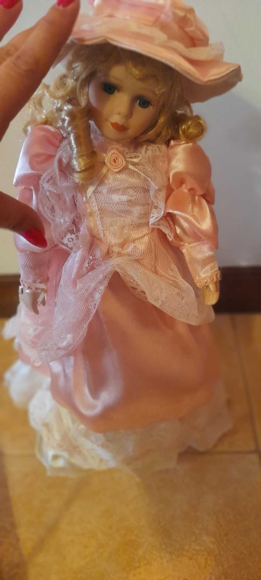 Boneca de porcelana com vestido e chapéu cor-de-rosa