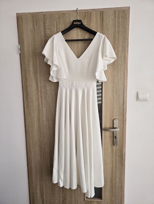 Sukienka midi suknia ślubna to kwintesencja kobiecego wdzięku i klasy.