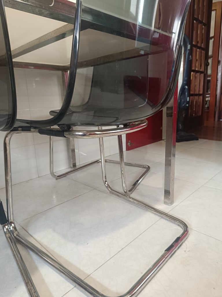 Mesa de vidro com estrutura metálica + 4 cadeiras acrílicas cinzentas