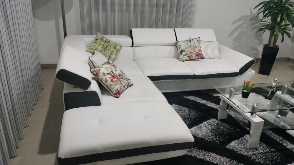 Sofá branco sintético,  em alguns sítios com marcas de uso