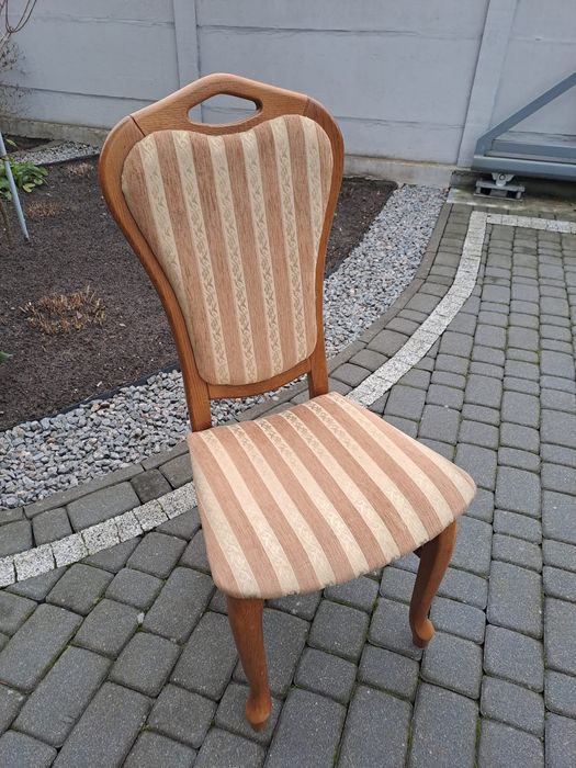 Krzesło drewniane z miękkim siedziskiem i oparciem.