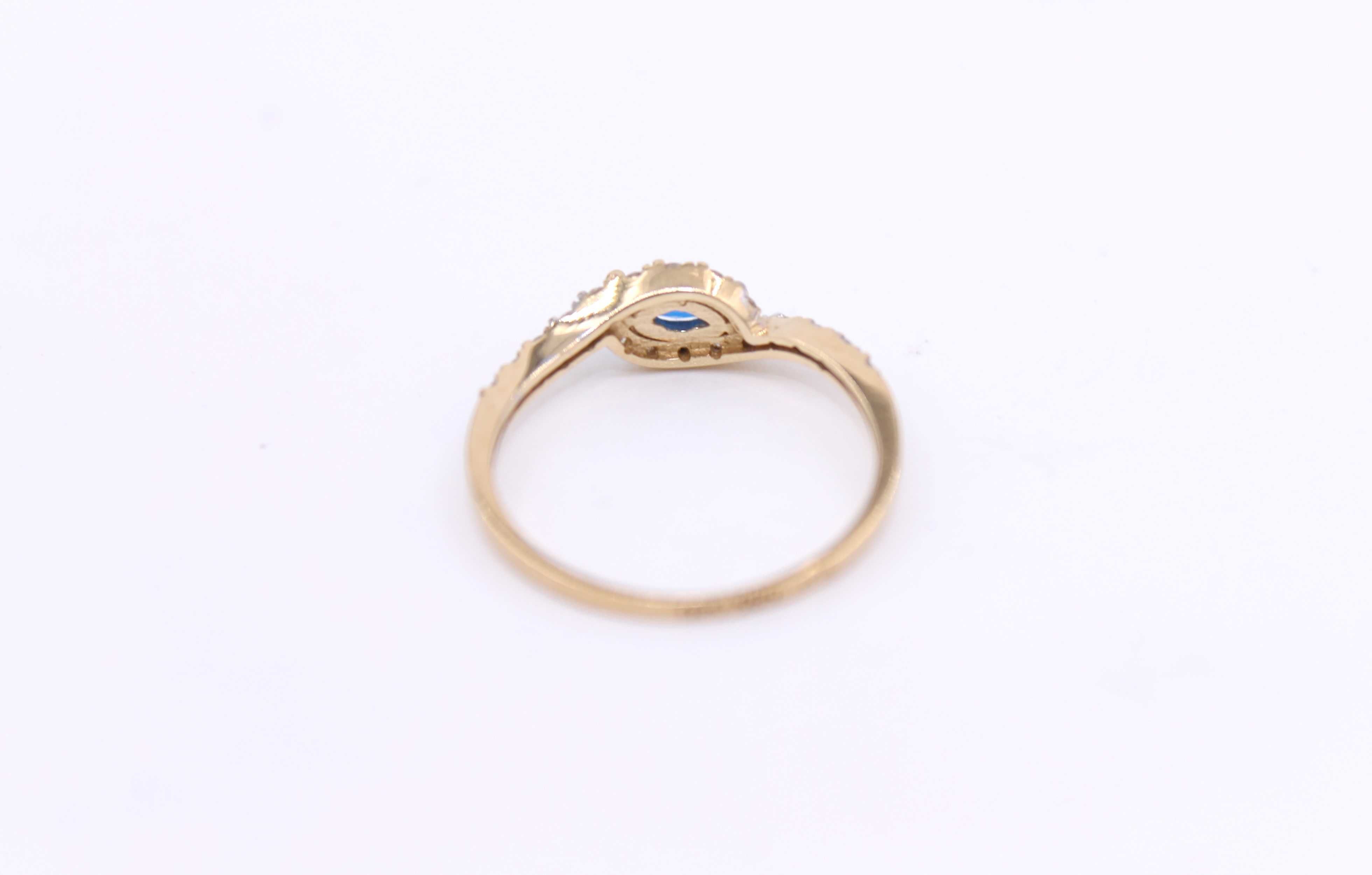 Złoty pierścionek p.585/1,26g z niebieskim kamieniem i cyrkonami