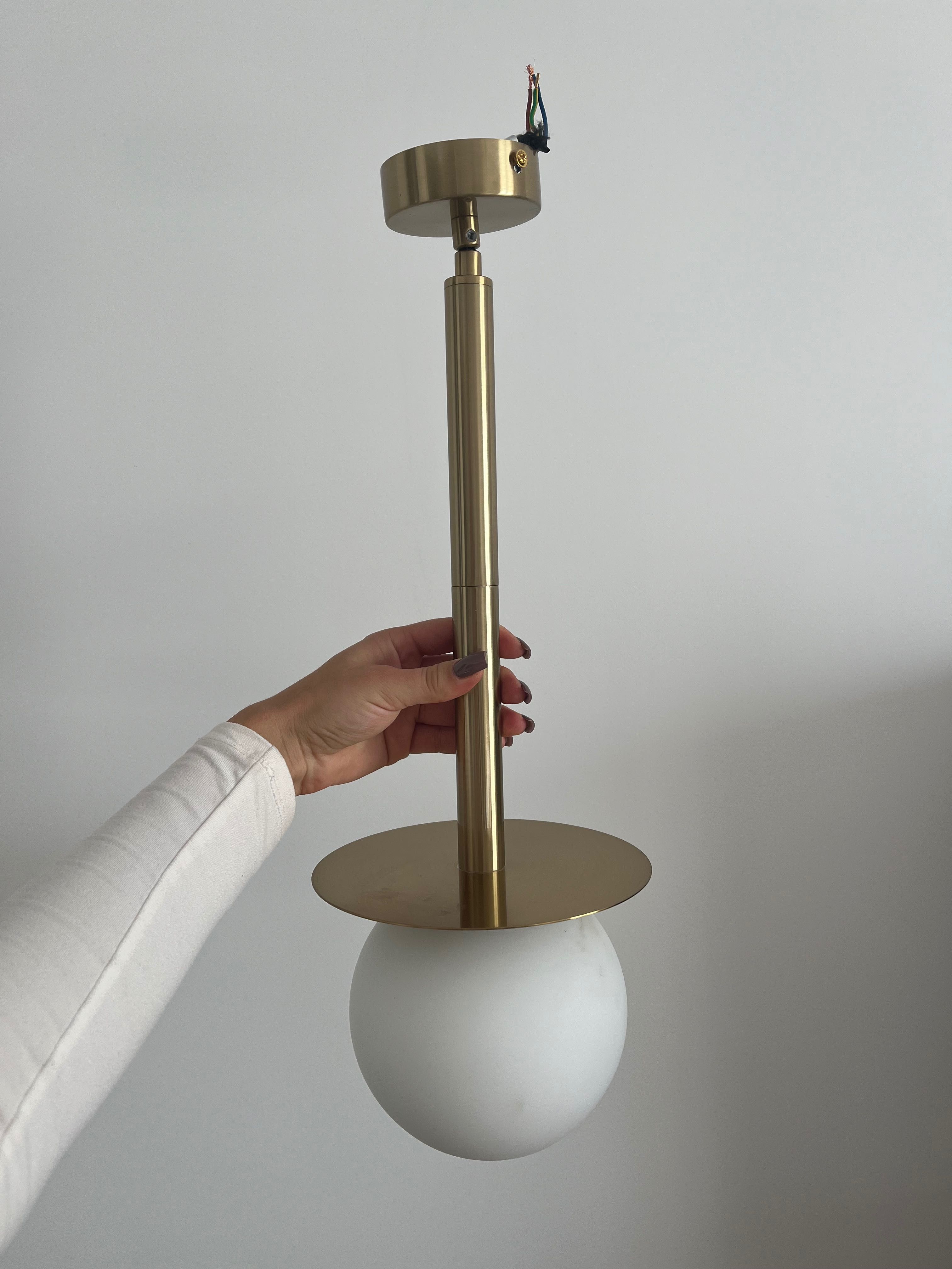 Złota lampa z białą kulą
