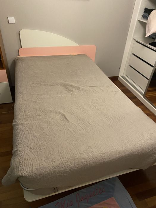 Cama em tons rosa e branco com suporte lateral