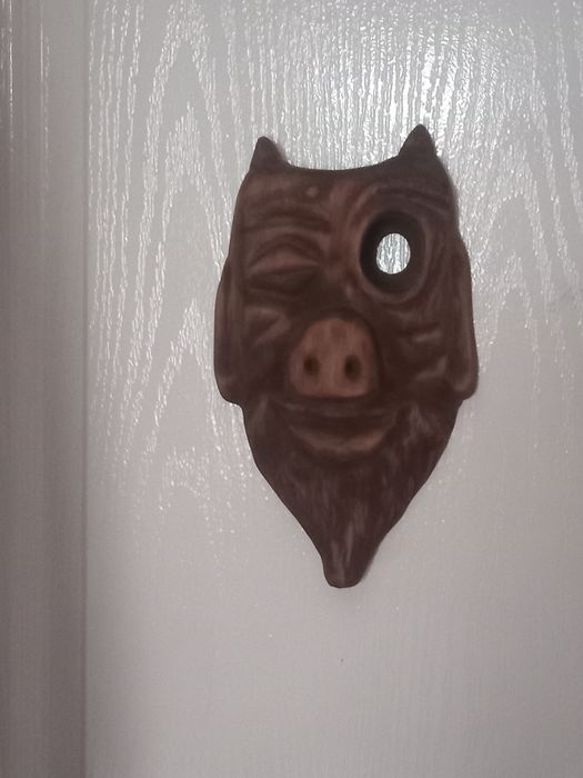 Маска чорта з глазком на двері.