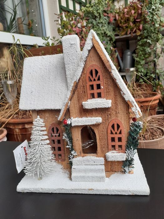 Drewniany ośnieżony domek z podświetleniem LED
