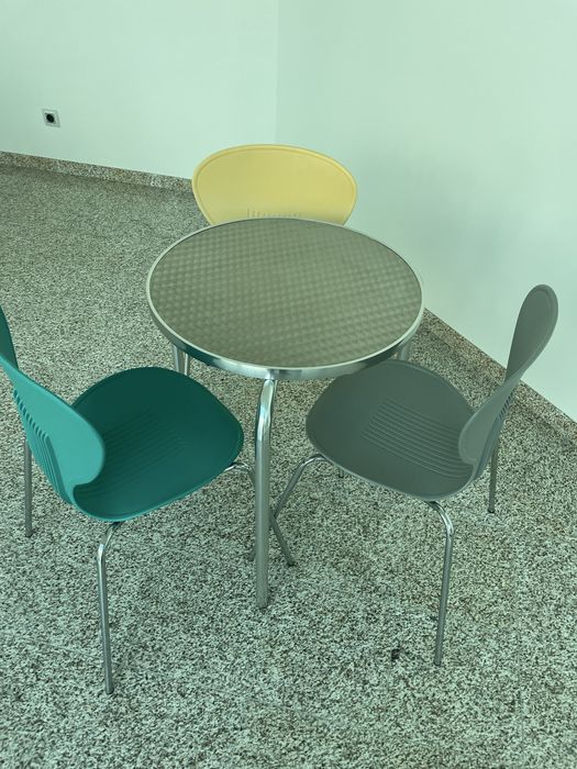Mesa de alumínio e cadeiras coloridas
