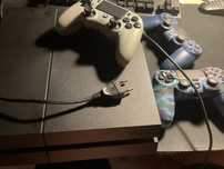 Consola ps4, três comandos e uma capa de um comando