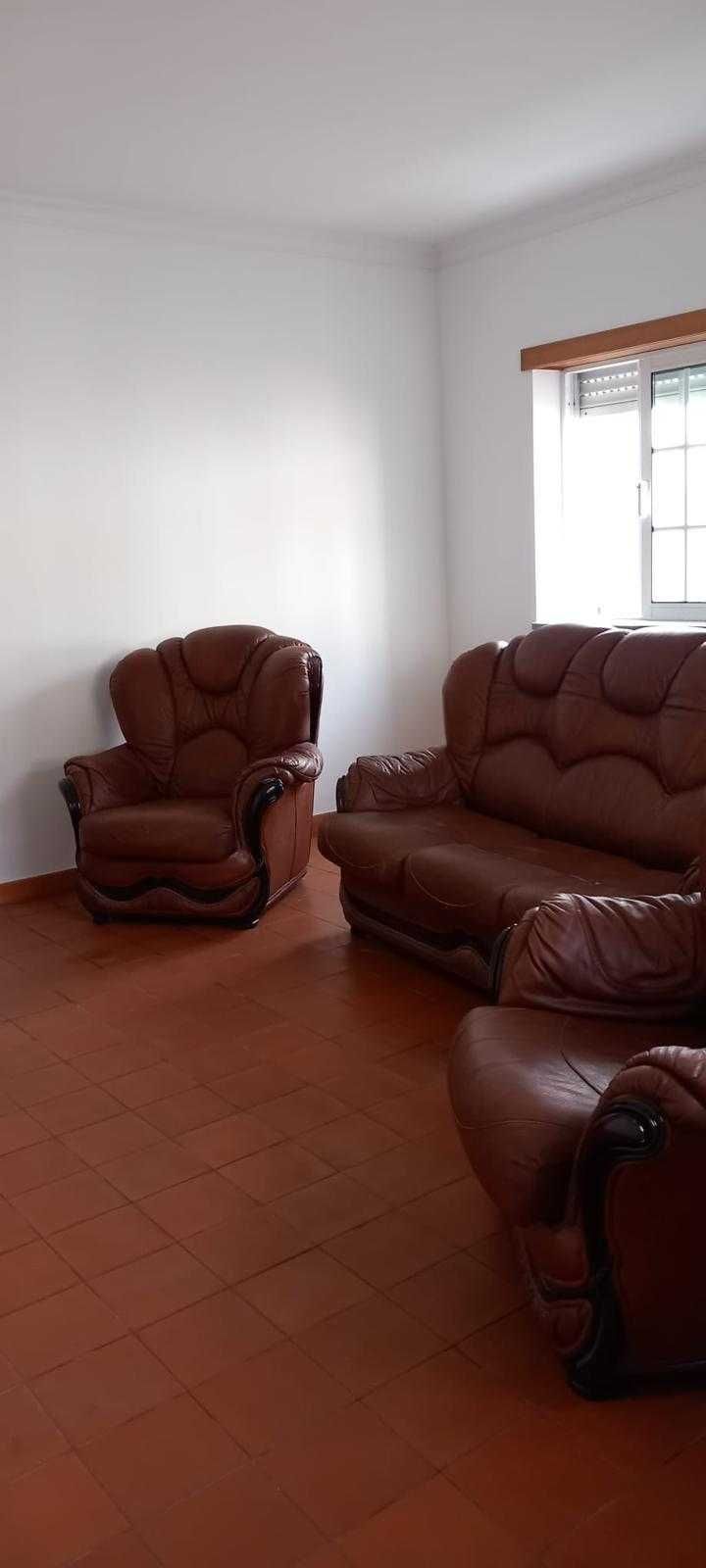 Sofás em pele cor castanho.