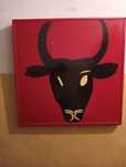 Quadro de touro  preto e vermelho a piscar o olho ligeiramente danific