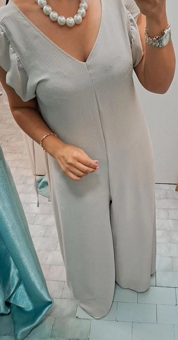 Macacão bege comprido, com folhos nos ombros. TU