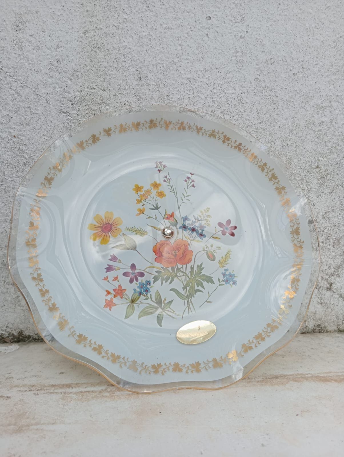Fruteira em vidro com o pé em metal, com motivos florais.