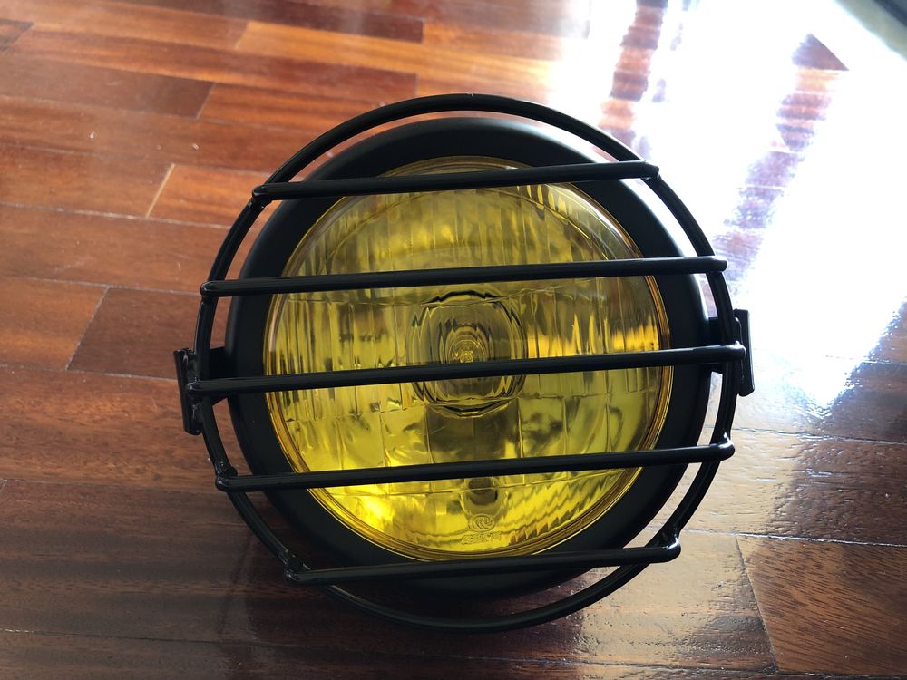 Farol frontal amarelo com grelha metálica dois apoios cafe racer