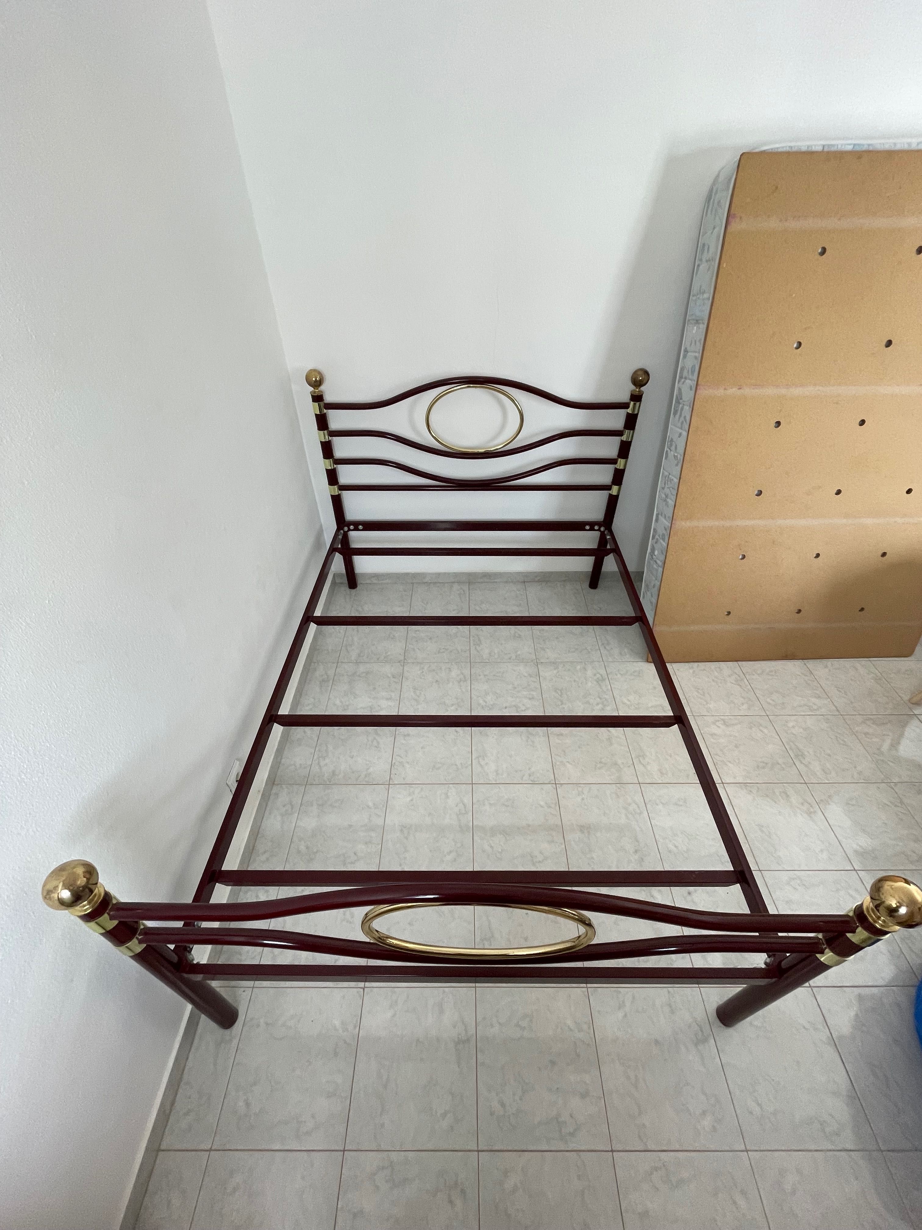 Cama de casal de metal com estrado e colchão.