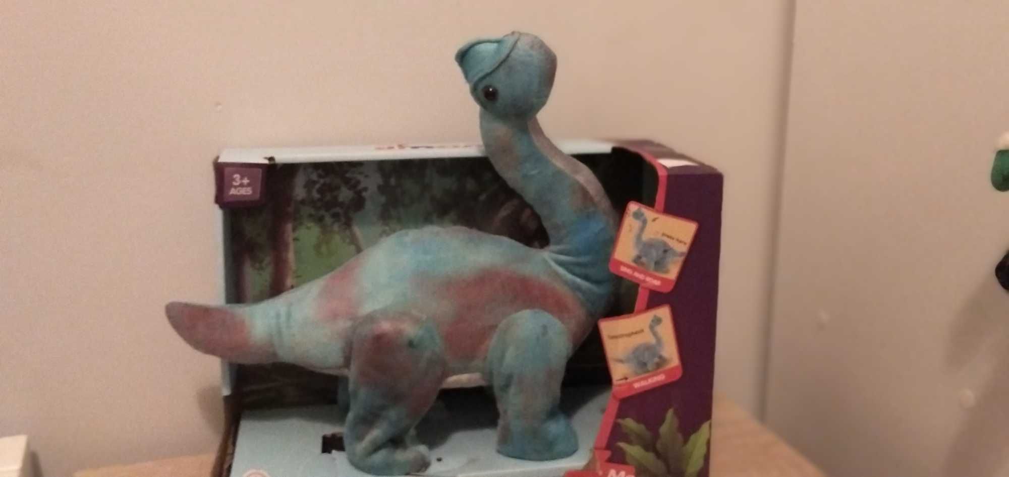 Zabawka chodzący i grajacy dinozaur