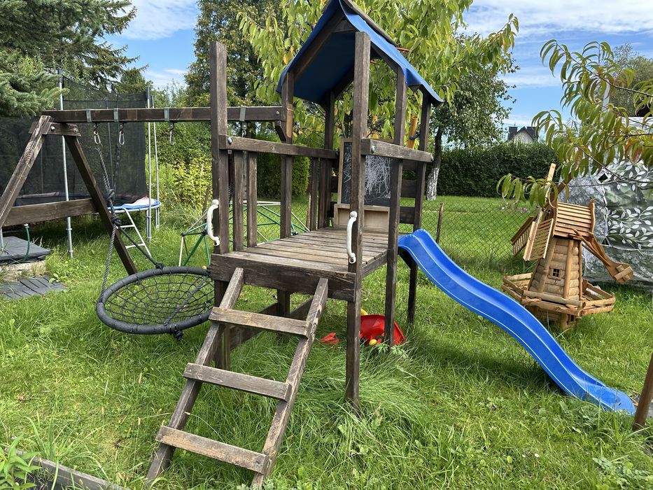 Plac zabaw, hustawka, zjeżdżalnia, domek, bocianie gniazdo.