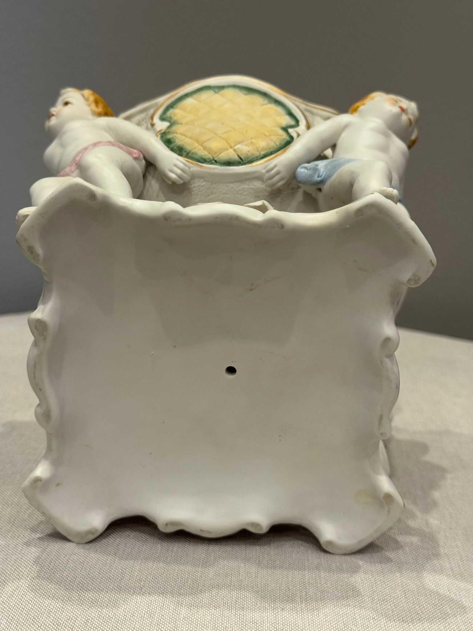 Misa (żardiniera) trzymana przez Putto, porcelana ręcznie malowana.