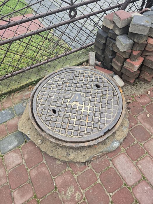 Właz żeliwny pokrywa studni szamba