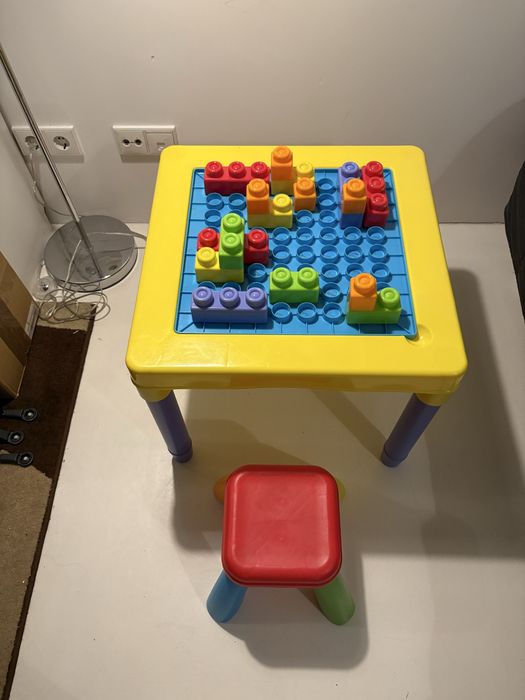 Mesa de brincar de criança com arrumacão, legos e banco para desocupar