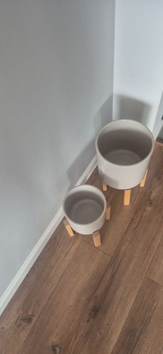 Dwie donnice porcelanowe beżowe na drewnianych stojakach