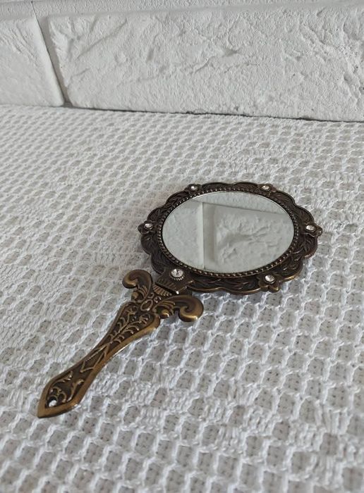 Lusterko z metalowej oprawie.