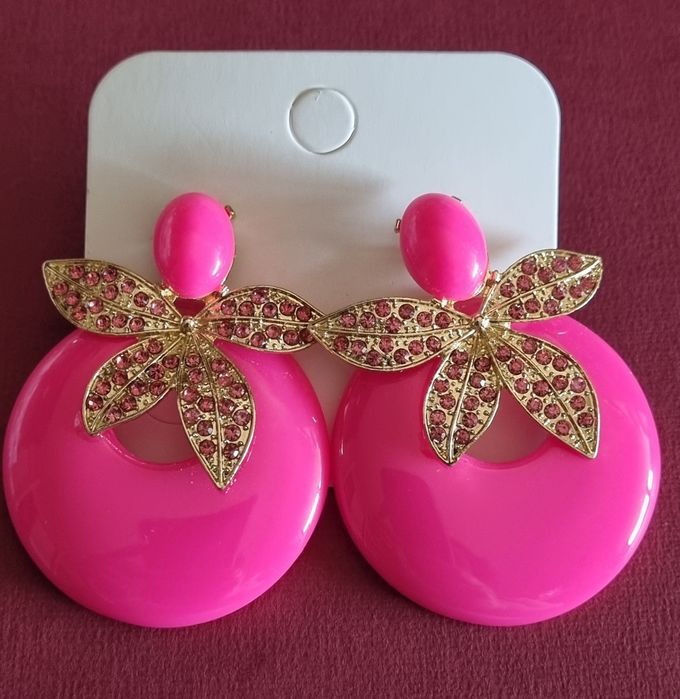 Brincos em acrílico, de pico, em rosa fucsia e apontamentos dourados.