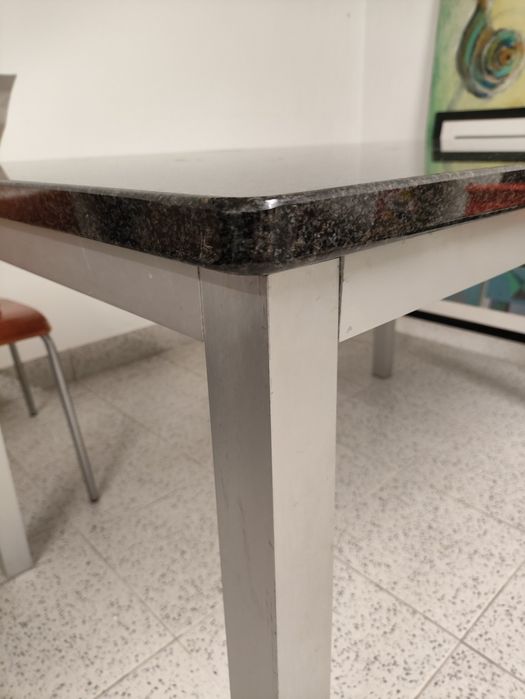 Mesa com tampo em granito, base das pernas em inox