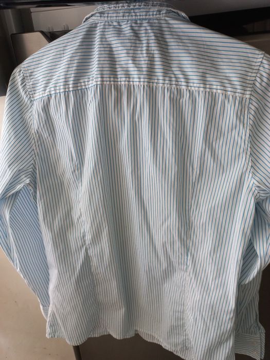 Camiseiro branco com riscas azuis.