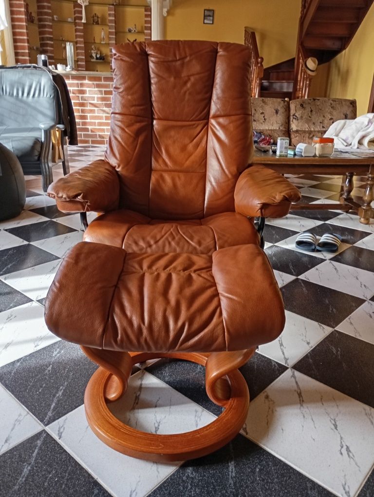 Cadeirão castanho com apoio de pés em couro castanho