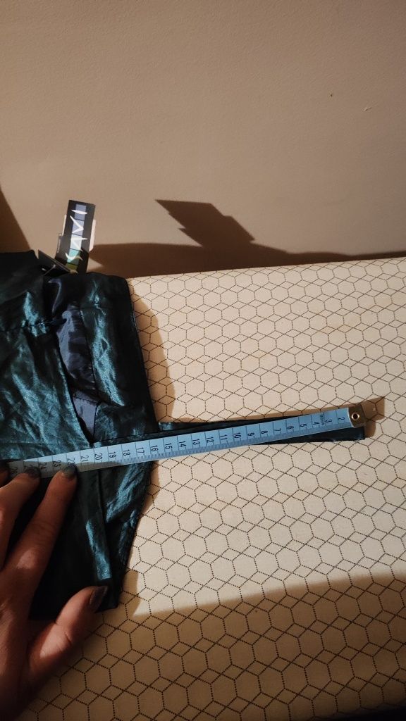 Sukienka typu bombka, z połyskującymi drobinkami metalu.