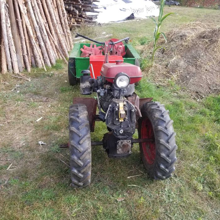 Mikrociągnik w zestawie z glebogryzarką, przyczepą i z papierami.
