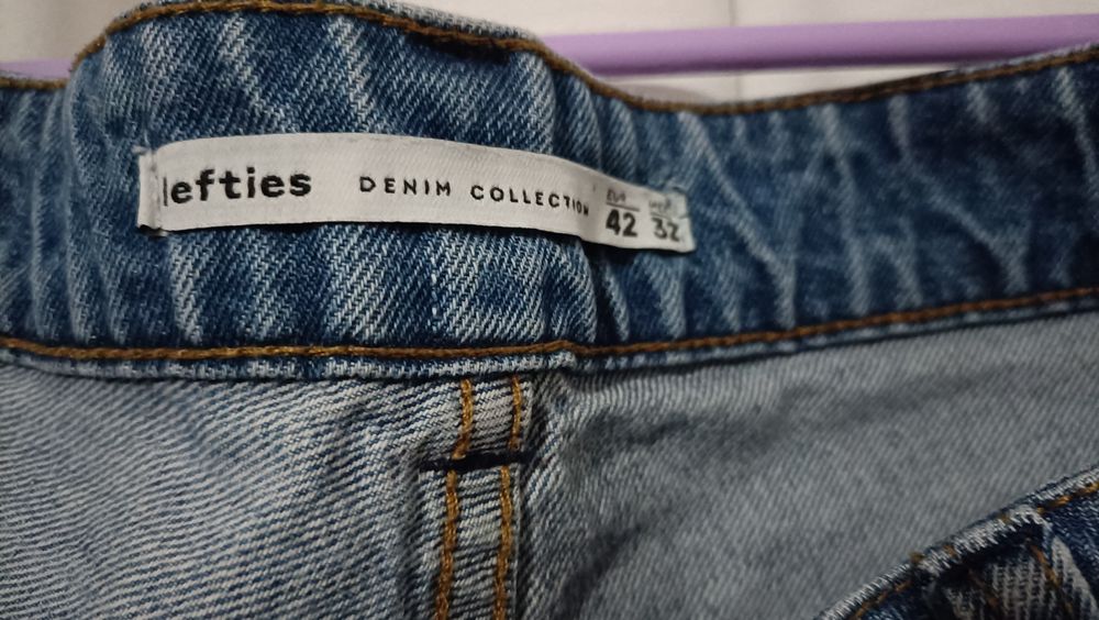 Calças de ganga para senhora com padrões de rosas vermelhas.