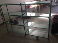 Estante de metal com prateleiras de vidro