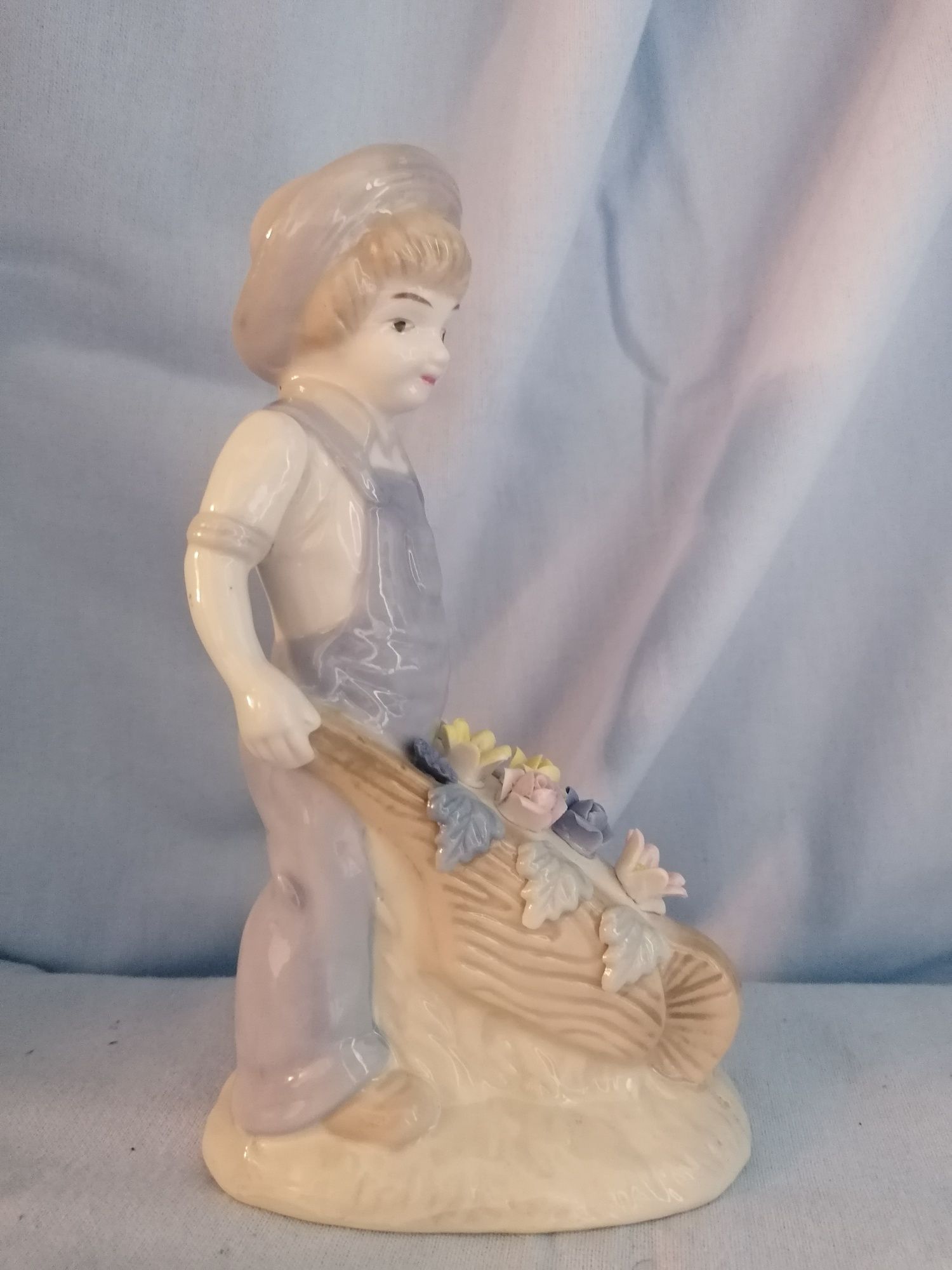Śliczna porcelanowa figurka chłopiec z taczką i kwiatami