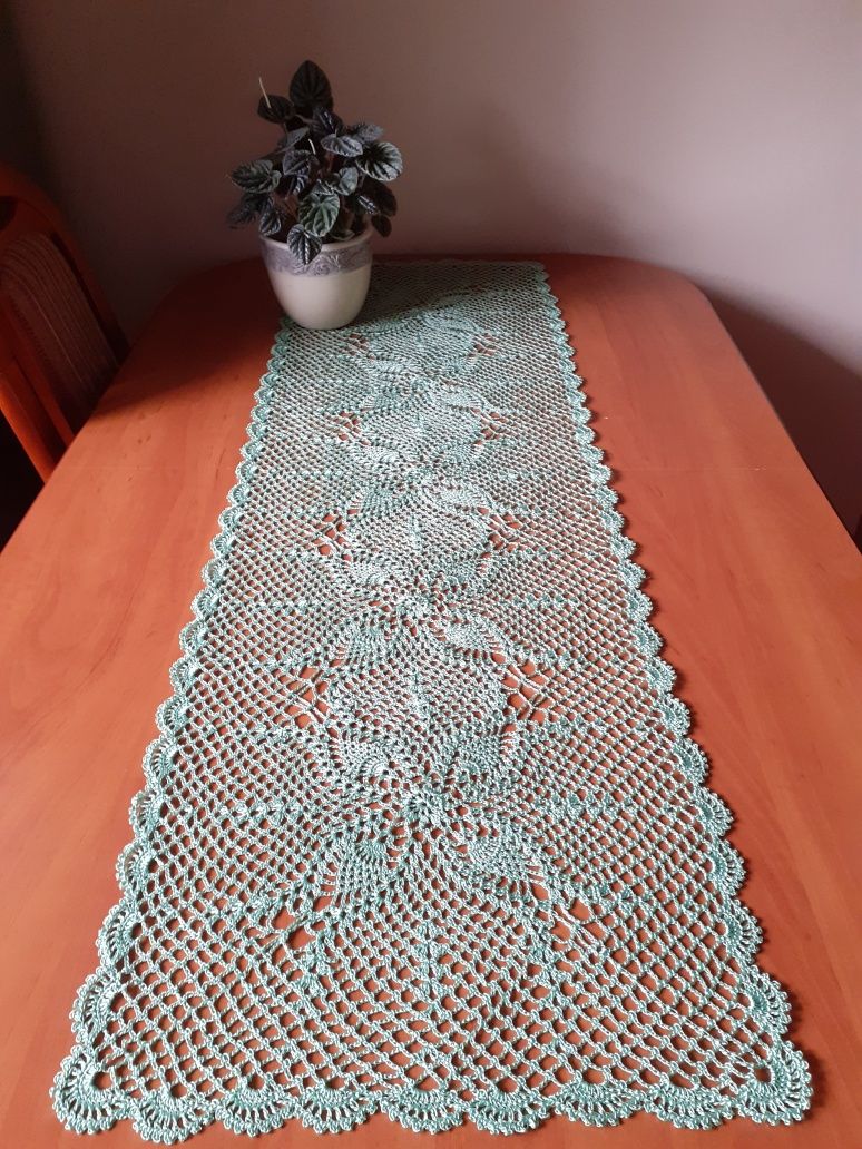 Bieżnik na stół lub ławę w kolorze jasnej zieleni.