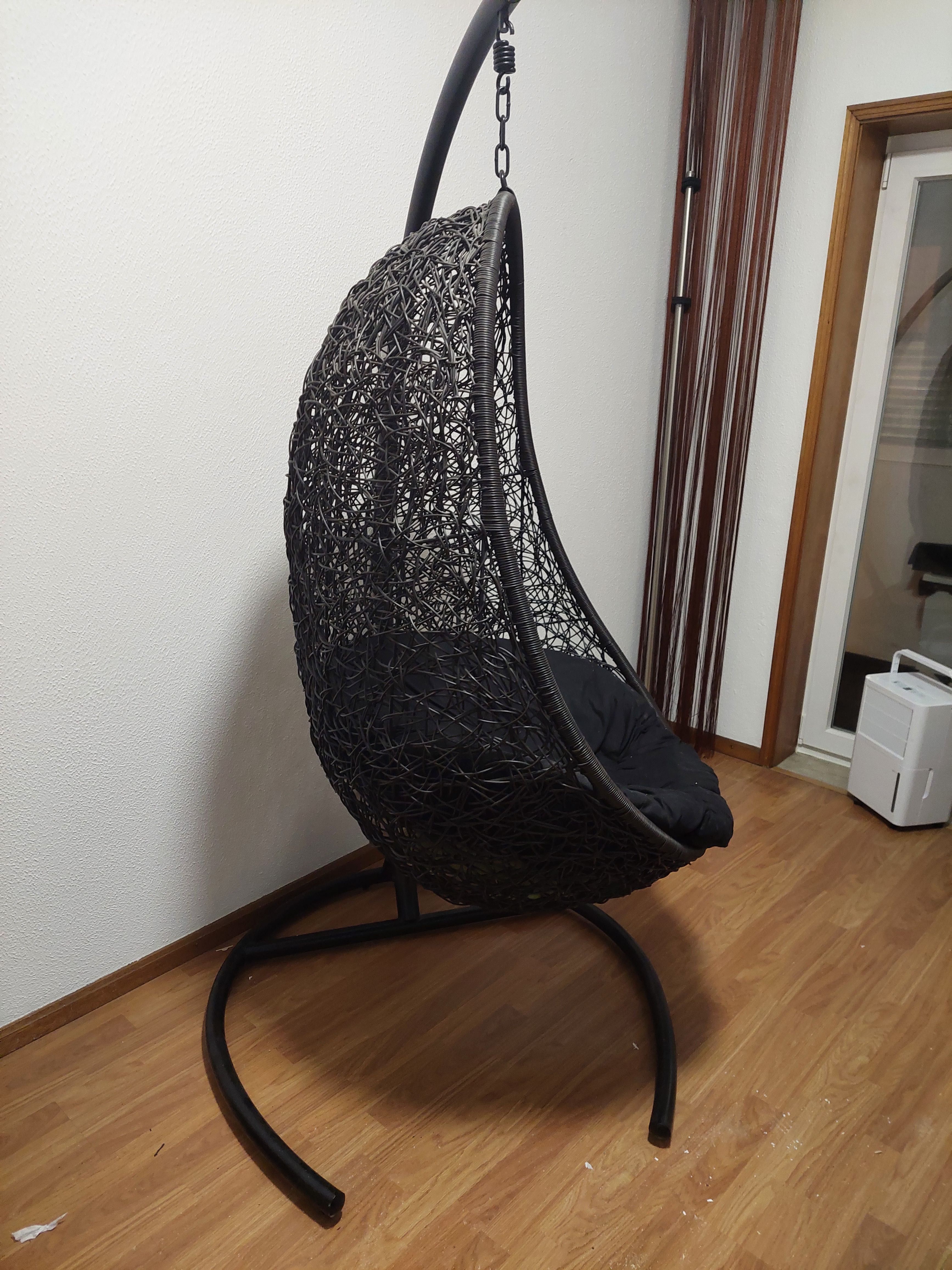 Cadeira suspensa de jardim com almofada.