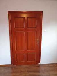 Drewniane drzwi pokojowe z ościeżnicą.